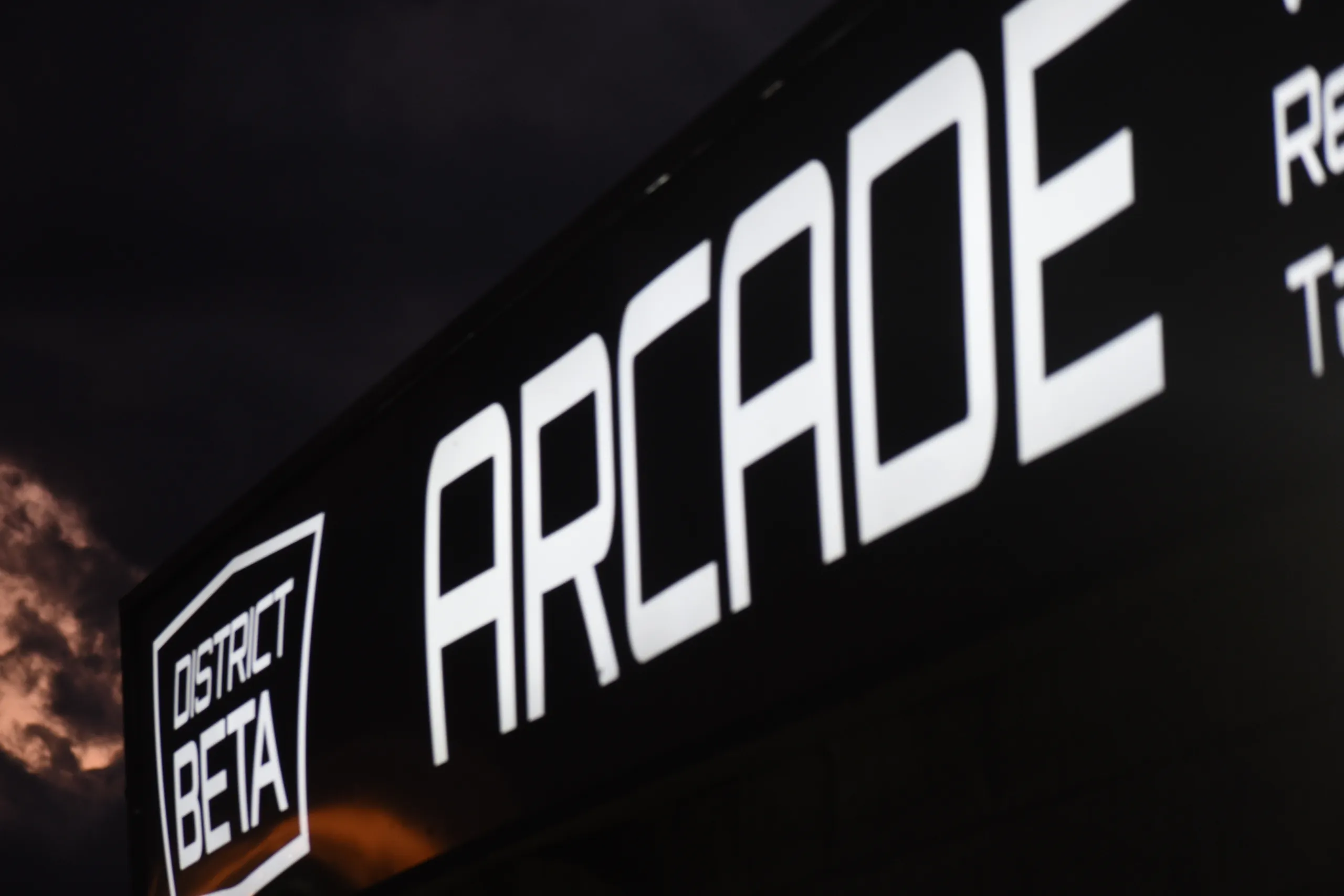 The District Beta ARCADE sign on the building at night