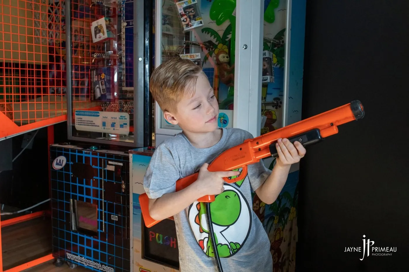 A kid aiming a light gun at an arcade cabinet