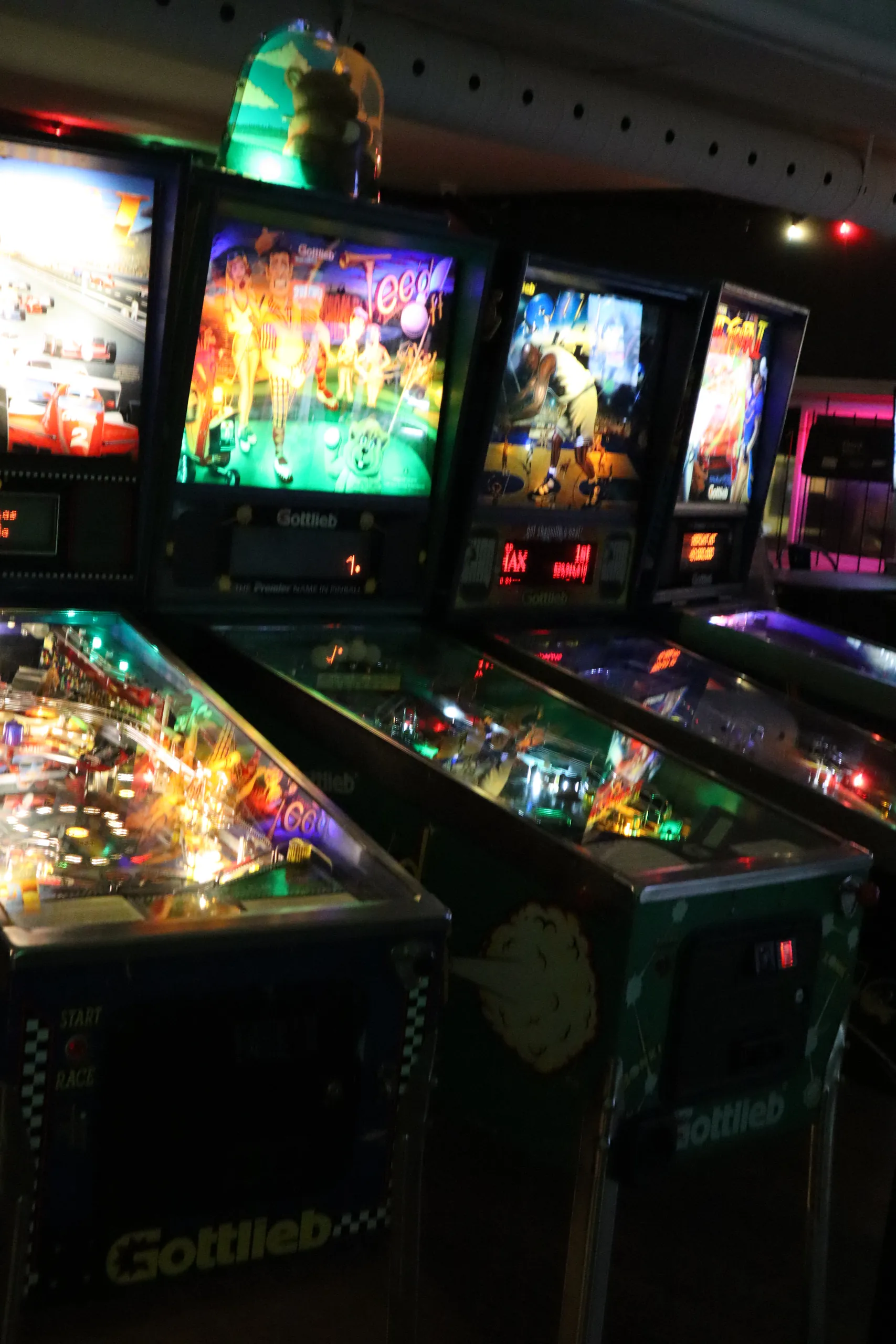 A row of lit pinball machines