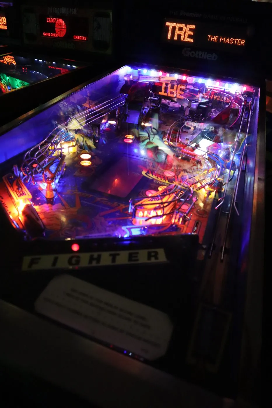 A pinball playfield lit up in purple and orange