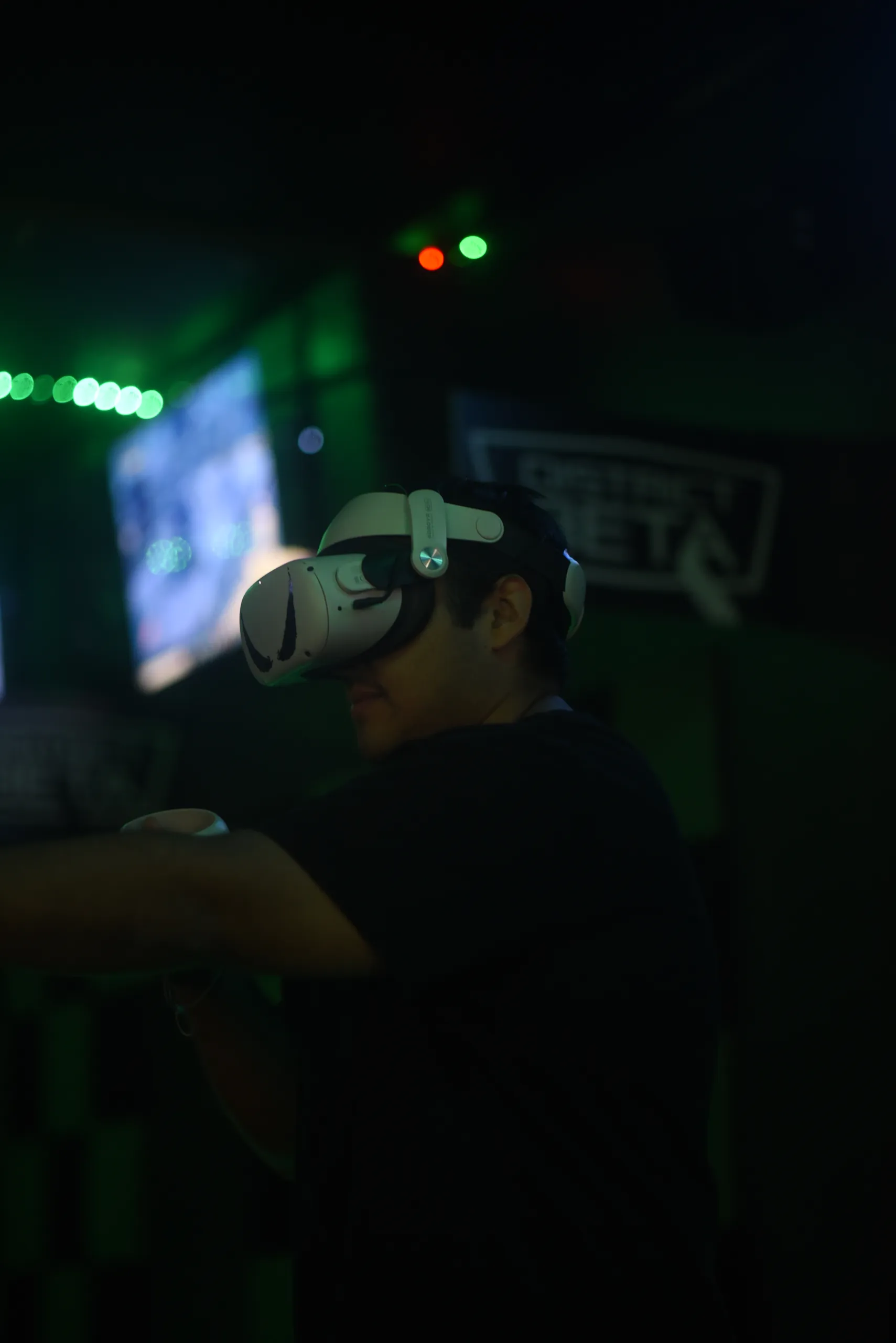 A player in a white VR headset reaching out inside a dark green chamber